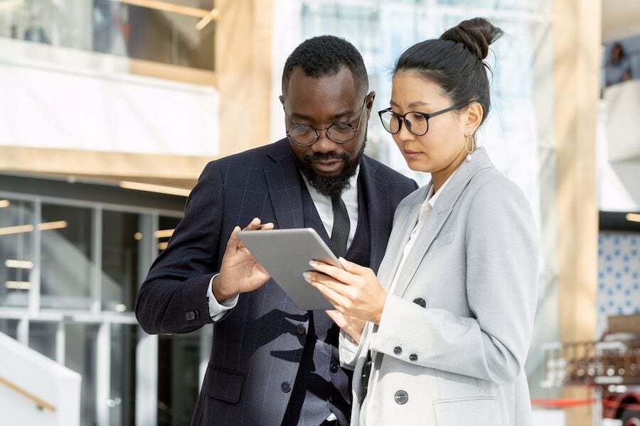 two-young-colleagues-in-formalwear-scrolling-throu-2022-01-18-23-51-45-utc-2-1